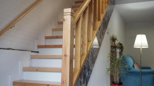 a wooden staircase in a living room with a blue couch at Casa Abuela Carmen in Arévalo