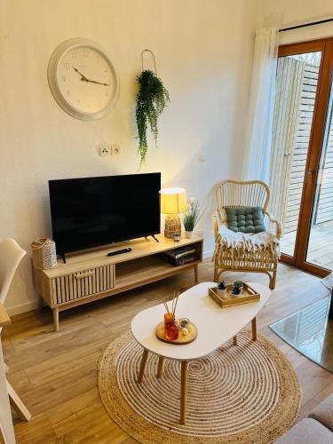 un salon avec une télévision et une table basse dans l'établissement Les Charmes - C24A, à Eppe-Sauvage