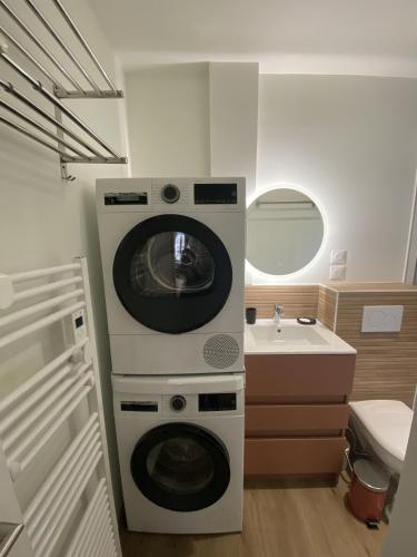 une machine à laver dans une salle de bain avec un lavabo dans l'établissement Appartement 2 etoiles haut de gamme Le Pompidou, à Les Sables-dʼOlonne