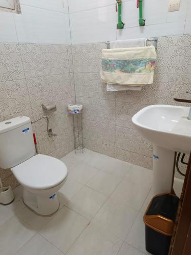 a bathroom with a toilet and a sink at AMAL HoME in Ouagadougou