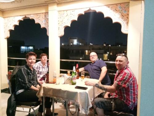 a group of men sitting at a table on a patio at Hotel Vijay Niwas in Jaipur