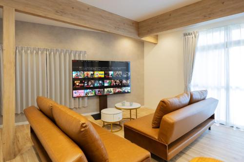 a living room with two couches and a flat screen tv at WONDERDREAM STAY NEW KASHIWA with Free parking in Kashiwa