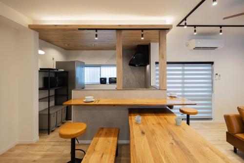 a kitchen with wooden tables and benches in a room at WONDERDREAM STAY NEW KASHIWA with Free parking in Kashiwa