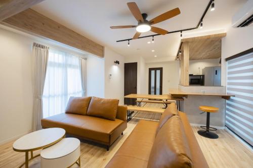 a living room with a couch and a ceiling fan at WONDERDREAM STAY NEW KASHIWA with Free parking in Kashiwa