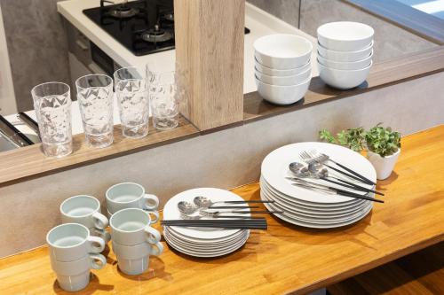 a table with plates and utensils on a counter at WONDERDREAM STAY NEW KASHIWA with Free parking in Kashiwa