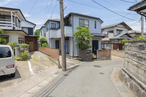 a white van parked on a street with houses at WONDERDREAM STAY NEW KASHIWA with Free parking in Kashiwa