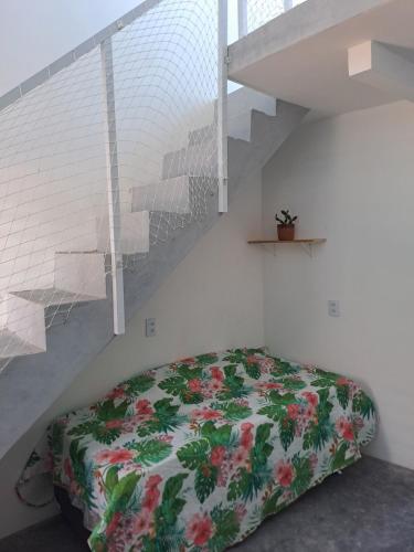 a bedroom with a bed with a flowered blanket at Vista Mar Emboaca in Estrela