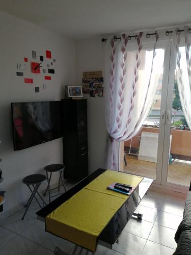 un salon avec une table et une télévision dans l'établissement Résidence ATHENA OREADE, à La Londe-les-Maures