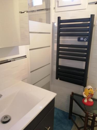 une cuisine blanche avec un évier et une chaise dans l'établissement Résidence ATHENA OREADE, à La Londe-les-Maures