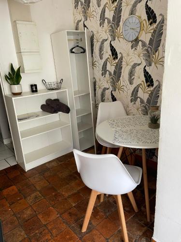 une table et une chaise dans une pièce avec une table et une horloge dans l'établissement Studio départ tardif proche gare et lycées, à Orléans