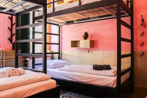 two bunk beds in a room with pink walls at Hostel ROOM Rotterdam in Rotterdam