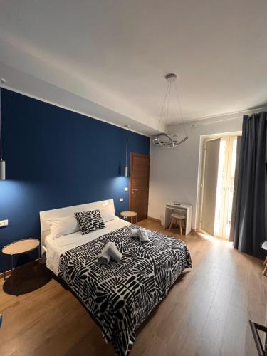 a bedroom with a large bed with a blue wall at B&B Onda Marina Villa Bellini Catania Centro in Catania