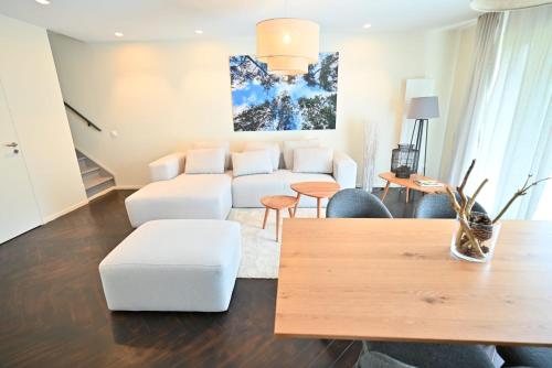 un salon avec un canapé blanc et des chaises dans l'établissement Natural Design Lodge Jacuzzi Privatif, à Milly-la-Forêt