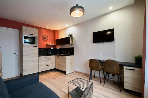 Il comprend un salon avec une cuisine équipée d'une table et de chaises. dans l'établissement Vieux Lille Appartement 2 personnes tout équipé, à Lille