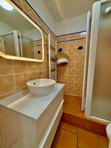 une salle de bain avec un lavabo et un miroir dans l'établissement Duplex vue mer dans résidence avec piscine et parking, à Théoule-sur-Mer