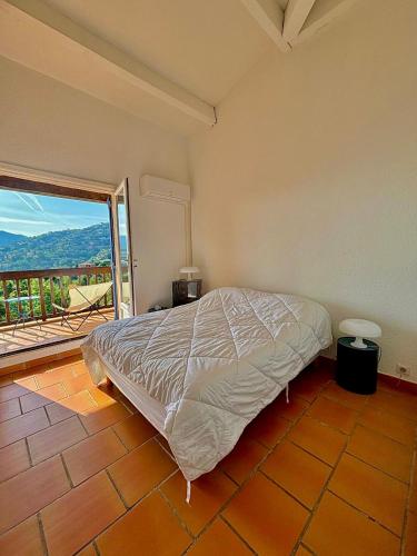 une chambre avec un lit et une grande fenêtre dans l'établissement Duplex vue mer dans résidence avec piscine et parking, à Théoule-sur-Mer
