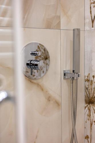 a shower head on a wall in a bathroom at BeB Domus Arbenzio San Giovanni Suite in Rome