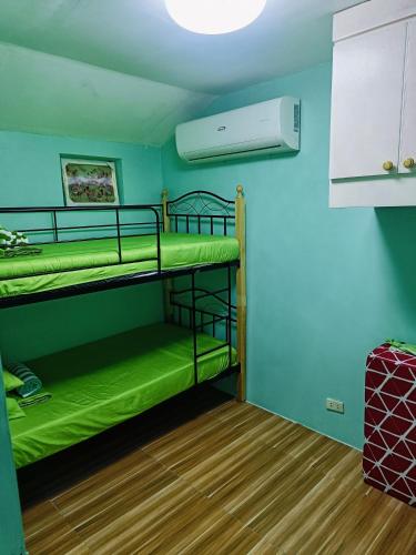 a room with two bunk beds and a fan at Divine's Cabin, Fully Airconditioned! in Tacondo