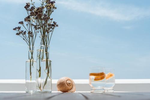 une table avec deux vases et un verre d'eau dans l'établissement Kastro suite, à Naxos Chora