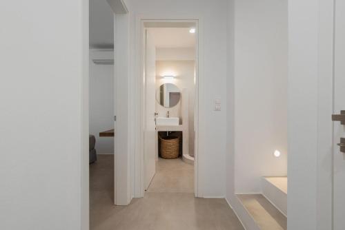 Un baño blanco con lavabo y espejo. en Villa Dia, Mikri Vigla Naxos, en Naxos Chora
