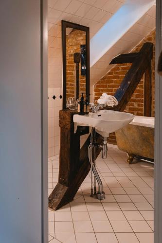 a bathroom with a sink and a tub and a mirror at Köpmans Boutique Hotel & Bistro in Höganäs