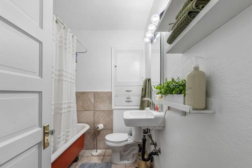 a white bathroom with a toilet and a sink at Cozy, Quiet 3BR Sugar House Hideaway by Mountains, Wi-Fi & Parking in Salt Lake City