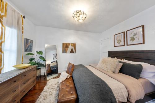 a bedroom with a large bed and a chandelier at Cozy, Quiet 3BR Sugar House Hideaway by Mountains, Wi-Fi & Parking in Salt Lake City