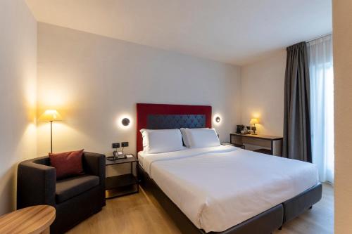 a hotel room with a large bed and a chair at Hotel Nordik Adults Only - Over 14 in Andalo