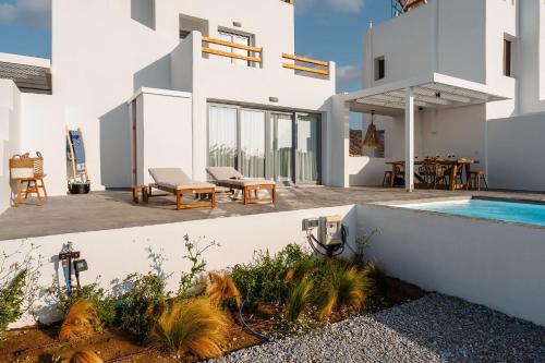 a white house with a swimming pool and a patio at Villa Kaya, Plaka in Naxos Chora
