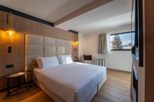 a bedroom with a large white bed and a window at Hotel Nordik Adults Only - Over 14 in Andalo
