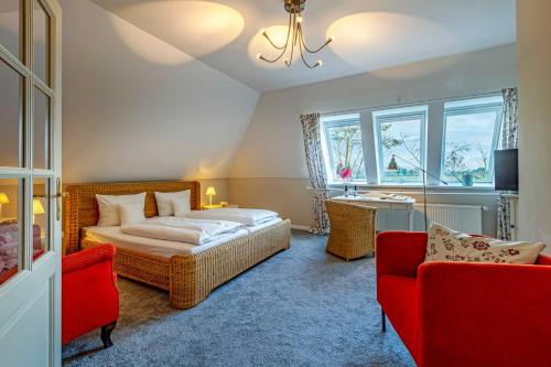 a bedroom with a bed and two chairs and a sink at Romantik Hotel Friederikenhof Hotel Restaurant & Spa in Lübeck