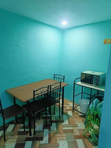 a dining room with a table and chairs and a microwave at Divine's Crib, Fully Airconditioned! in Tacondo