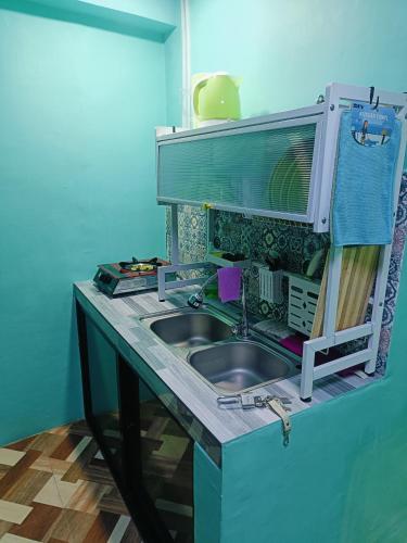 a kitchen with a sink in a counter top at Divine's Crib, Fully Airconditioned! in Tacondo