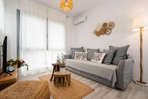 a living room with a couch and a table at Yara Apt 40m from the Beach Jacuzzi & Rooftop in Agia Anna Naxos