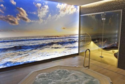a bathroom with a large television with a bath tub at Hotel Riant-Séjour by WP Hotels in Blankenberge