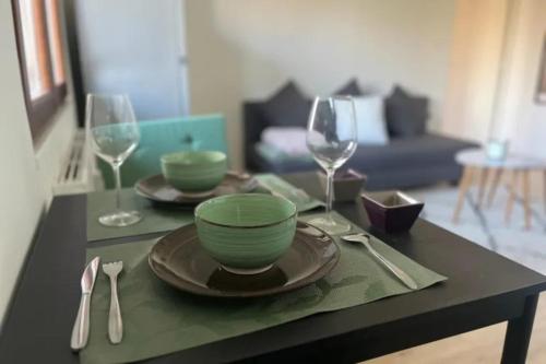 - une table avec deux assiettes et deux verres à vin dans l'établissement SOH Rent Strasbourg appartement wifi terrasse, à Strasbourg