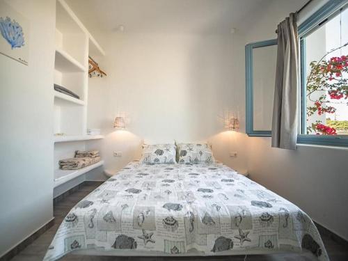 un dormitorio con una cama y una ventana en Magnifica, en Naxos Chora