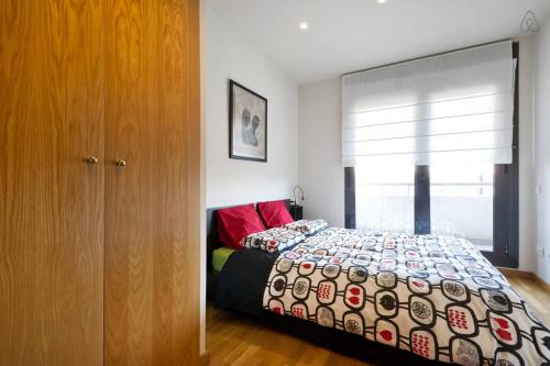 1 dormitorio con cama y ventana grande en Apartment familiar, en Barcelona