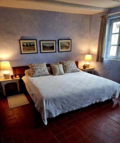 une chambre avec un grand lit blanc avec deux lampes dans l'établissement La Maison de Piolon, à Beaumont-du-Ventoux