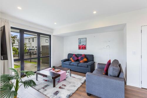 a living room with a couch and a table at Auckland airport homes six minutes from airport three bedrooms two and half bathrooms in Auckland