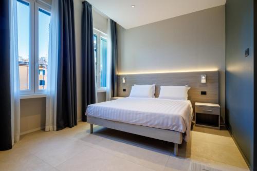 a bedroom with a bed and two windows at Casa San Giuseppe in Rome
