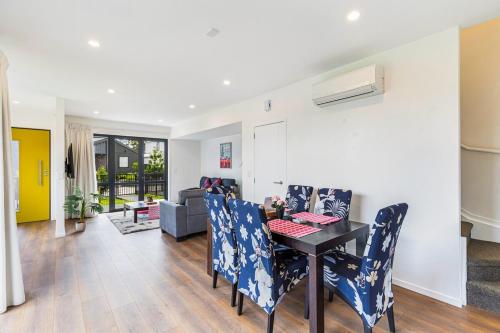 a dining room and living room with a table and chairs at Auckland airport homes six minutes from airport three bedrooms two and half bathrooms in Auckland