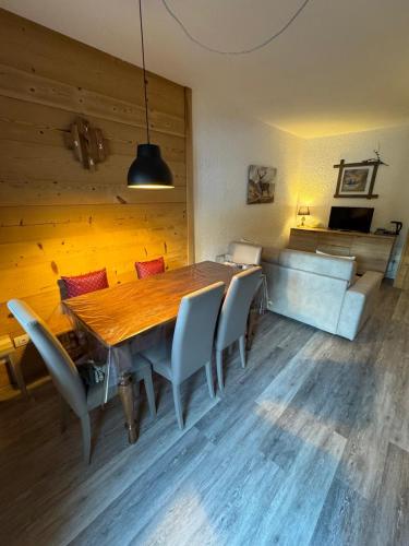 a dining room with a wooden table and chairs at Solimmo in Temù
