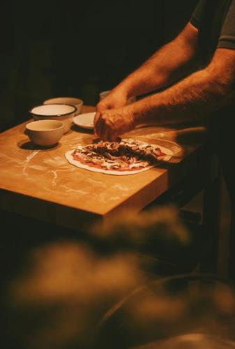 a person making a pizza on a table at Szopa in Ustrzyki Dolne
