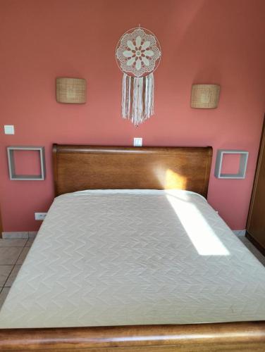a large bed in a room with pink walls at Gite emilouise in Carnoules