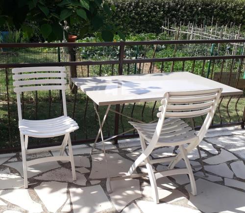 a white table and two chairs next to a fence at Gite emilouise in Carnoules