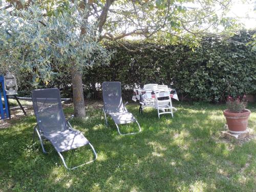 three chairs and a table in a yard at Gite emilouise in Carnoules