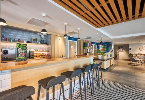 a bar in a restaurant with stools at a counter at B&B HOTEL Deauville-Touques in Deauville