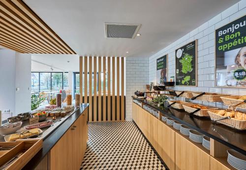a restaurant with a buffet line with food at B&B HOTEL Deauville-Touques in Deauville