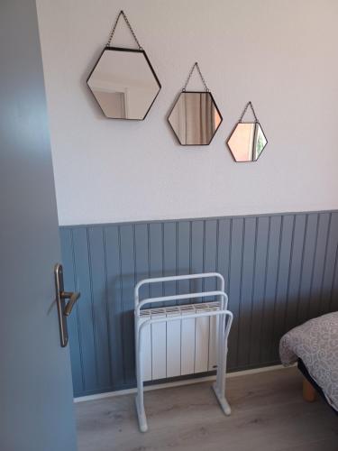 Cette chambre comprend un lit bébé et 3 miroirs sur le mur. dans l'établissement Appartement en résidence, à Saint-Cyprien